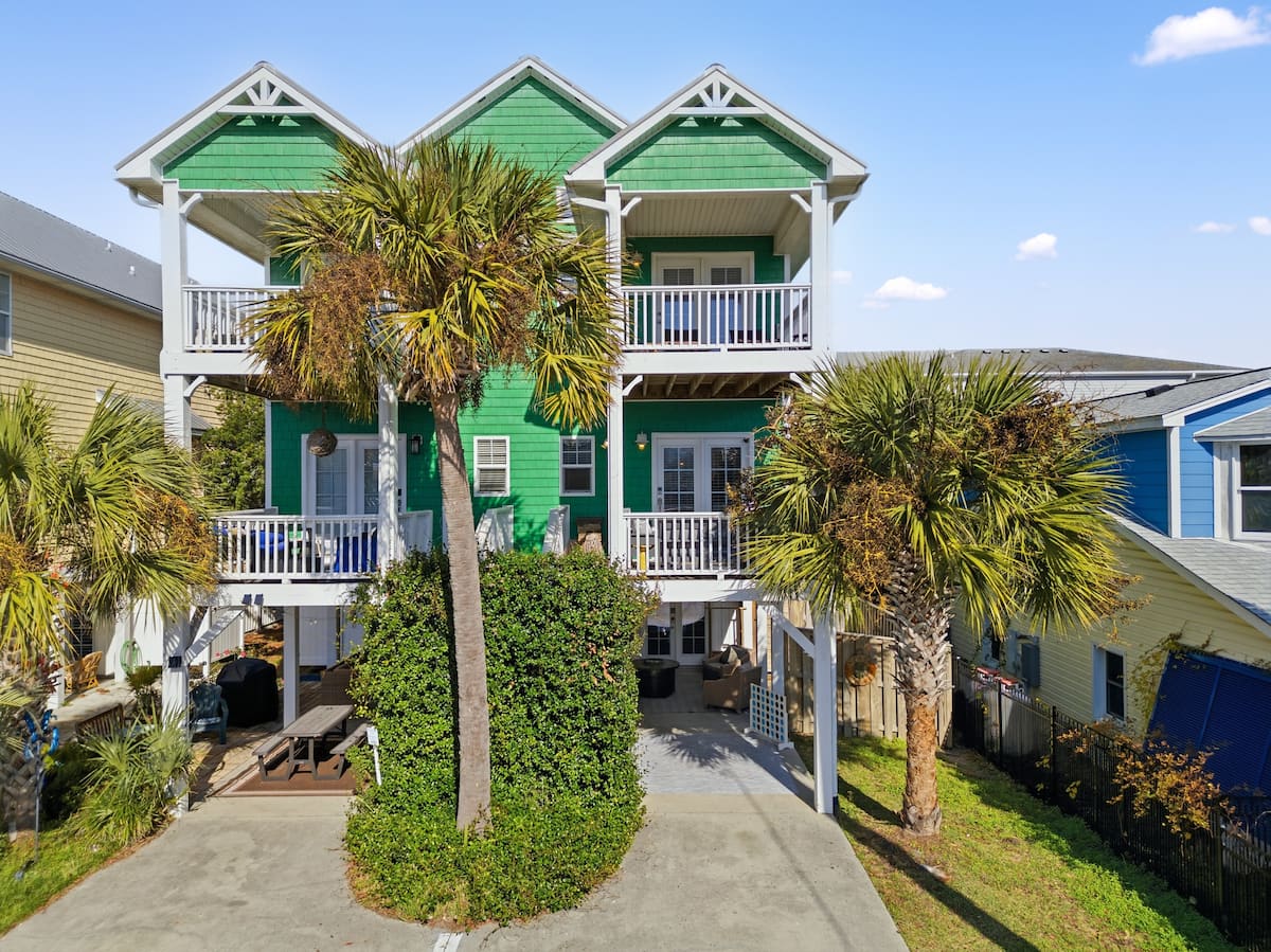 Green Carolina Beach home framed by palm trees